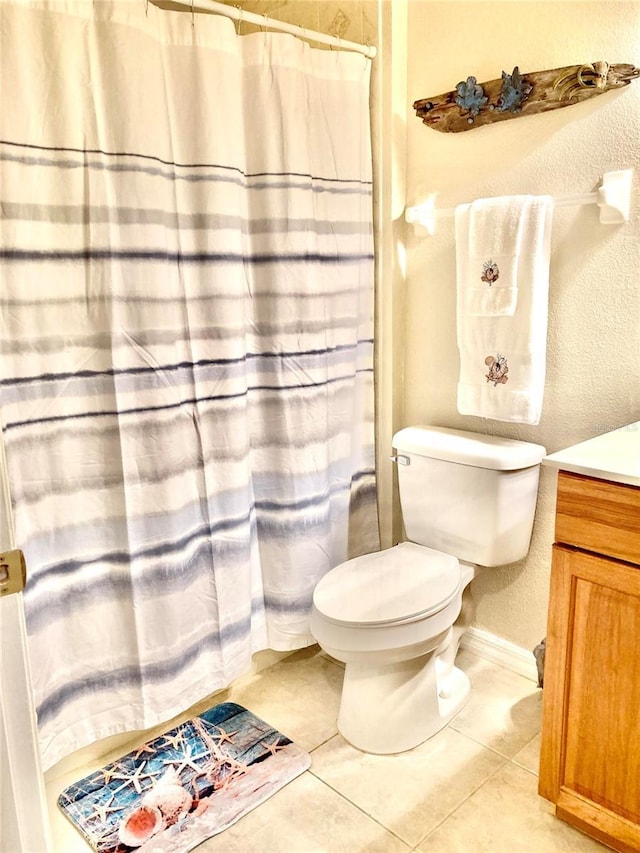 bathroom with tile patterned floors, a shower with curtain, toilet, a textured wall, and vanity