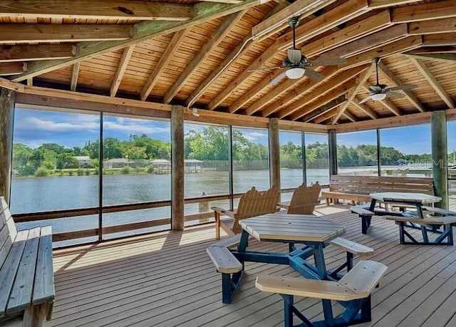 sunroom / solarium with a ceiling fan, beamed ceiling, and a water view