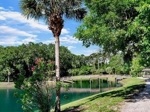 view of home's community featuring fence, a gazebo, and a water view