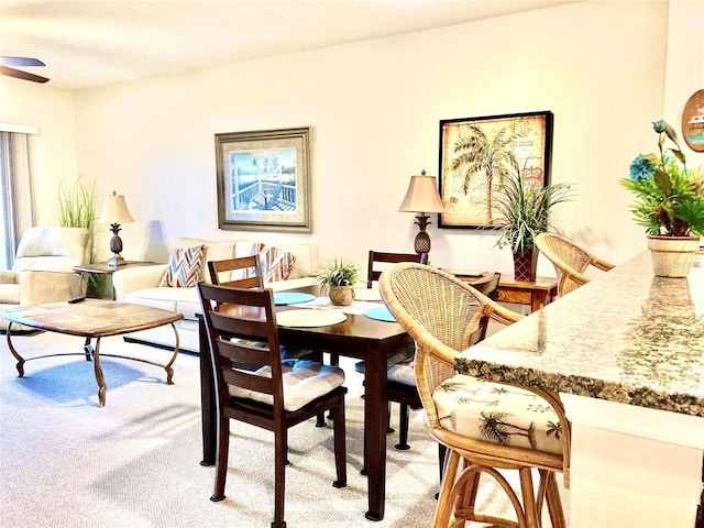 dining room featuring a ceiling fan and light colored carpet