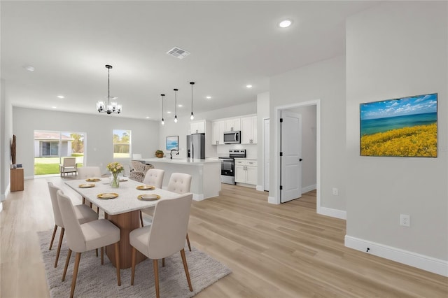 dining space with light wood-style flooring, visible vents, a chandelier, baseboards, and recessed lighting