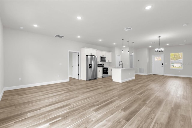 unfurnished living room featuring recessed lighting, a chandelier, and visible vents