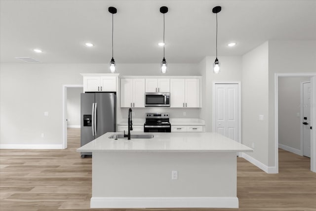 kitchen featuring white cabinets, a sink, stainless steel appliances, and light wood-style floors