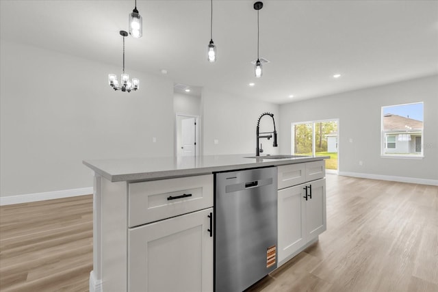 kitchen featuring dishwasher, light wood-style flooring, a sink, and baseboards