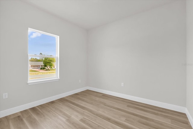 unfurnished room with baseboards and light wood-type flooring