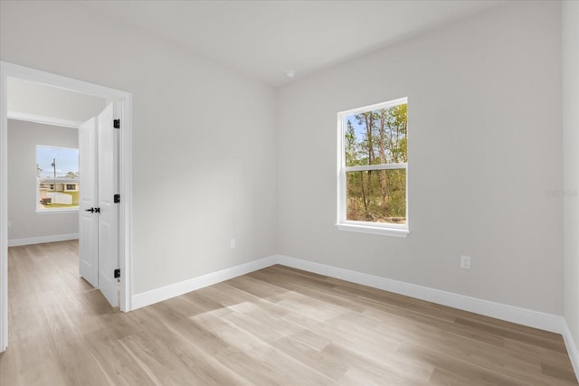 unfurnished room with baseboards and light wood finished floors