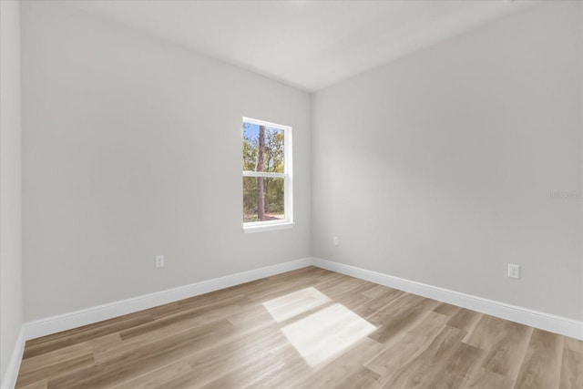 unfurnished room featuring baseboards and light wood-type flooring