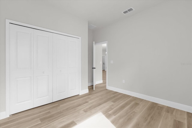 unfurnished bedroom featuring light wood-type flooring, baseboards, and visible vents