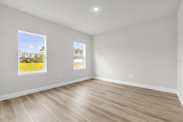 spare room featuring baseboards, light wood-style flooring, and recessed lighting