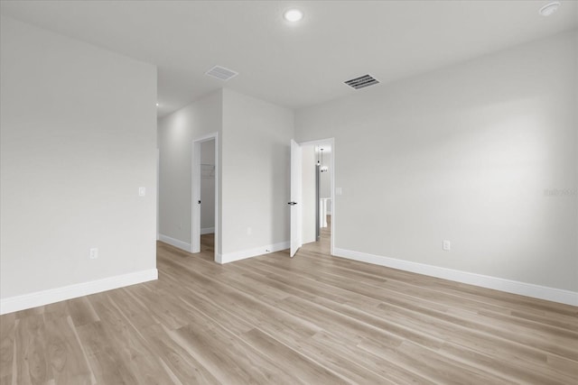 spare room with recessed lighting, baseboards, light wood-style floors, and visible vents