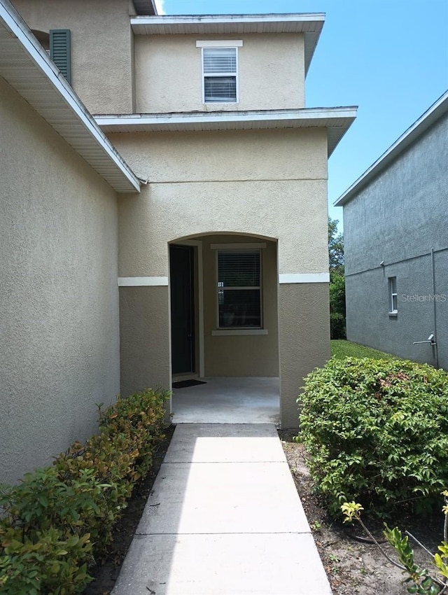 property entrance with stucco siding