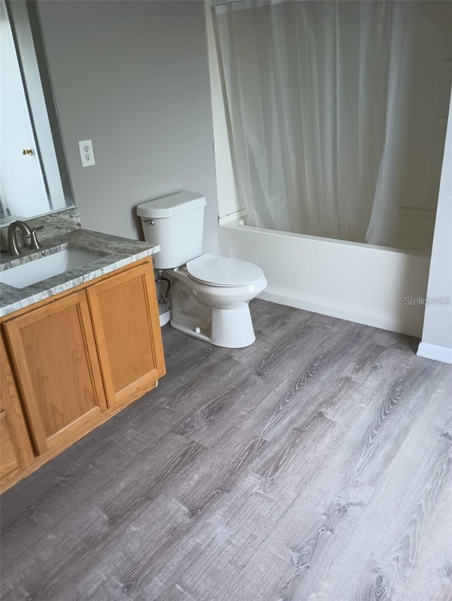 full bathroom with vanity, shower / bath combination with curtain, toilet, and wood finished floors