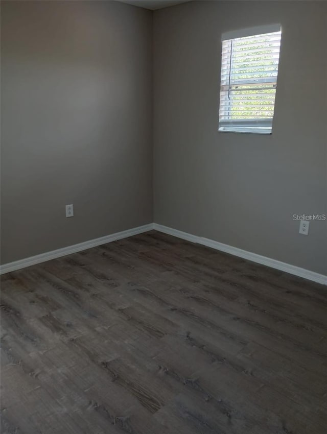 empty room featuring baseboards and wood finished floors