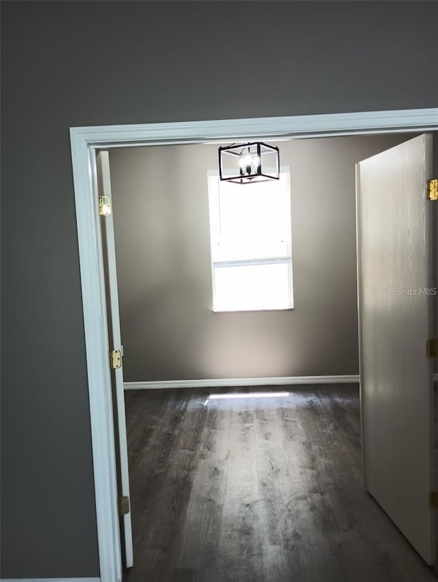 unfurnished dining area with baseboards and wood finished floors