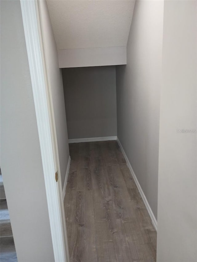 interior space featuring wood finished floors, baseboards, and a textured ceiling