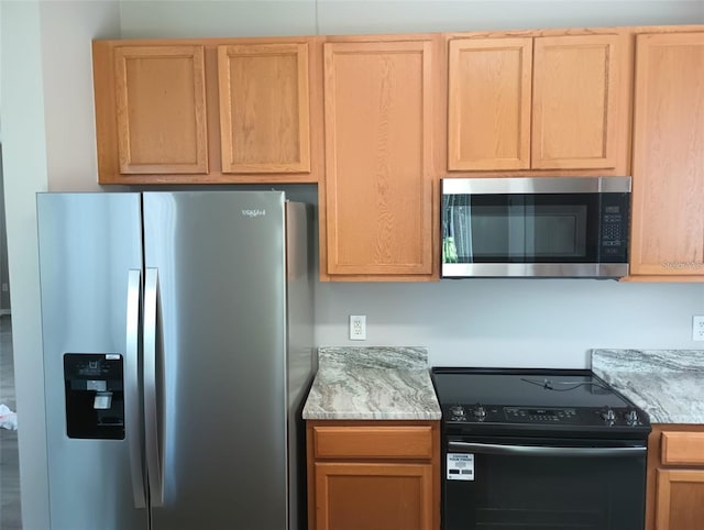 kitchen featuring light stone countertops and stainless steel appliances