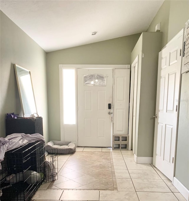 entrance foyer with baseboards and vaulted ceiling