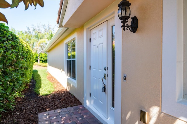 view of exterior entry with stucco siding