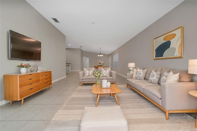 living area featuring light tile patterned floors, visible vents, baseboards, and vaulted ceiling