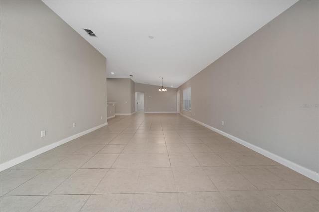 spare room featuring visible vents, baseboards, lofted ceiling, light tile patterned floors, and a notable chandelier