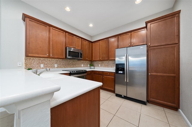 kitchen featuring a peninsula, backsplash, brown cabinets, and appliances with stainless steel finishes