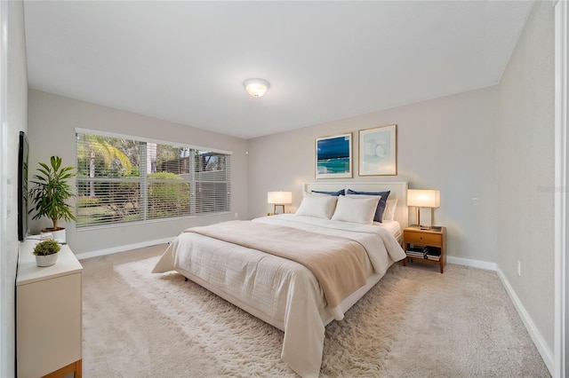 bedroom featuring light colored carpet and baseboards