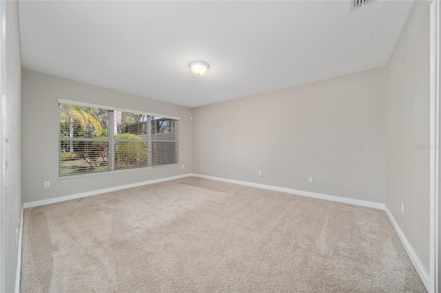 spare room featuring carpet and baseboards