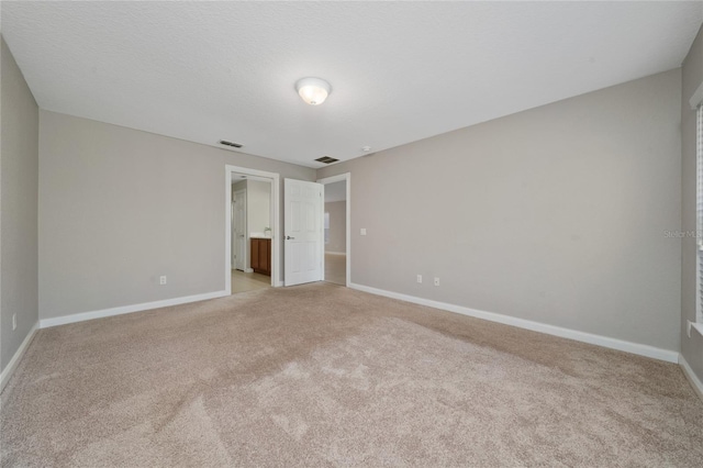 unfurnished bedroom featuring visible vents, baseboards, and light colored carpet