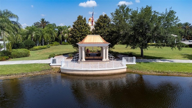 view of property's community with a gazebo, a lawn, and a water view