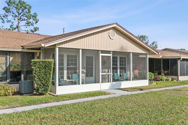 rear view of property with a yard and cooling unit