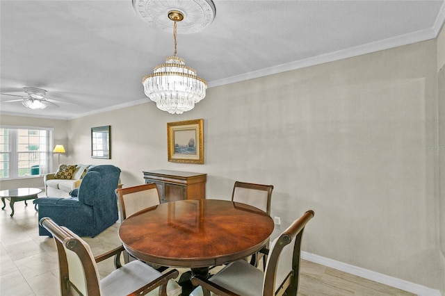 dining space featuring crown molding, ceiling fan with notable chandelier, and baseboards