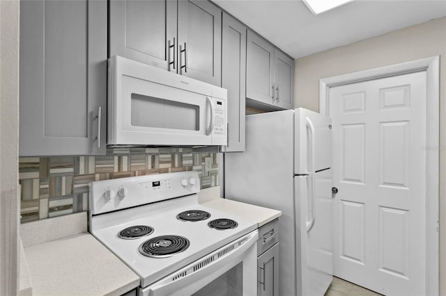 kitchen with white appliances, light countertops, and gray cabinetry