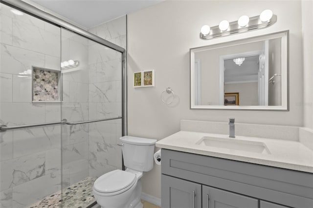 full bath featuring a marble finish shower, toilet, and vanity