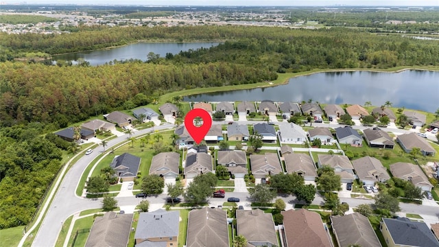 drone / aerial view with a forest view, a residential view, and a water view