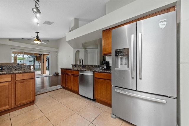 kitchen featuring light tile patterned floors, visible vents, appliances with stainless steel finishes, and brown cabinetry