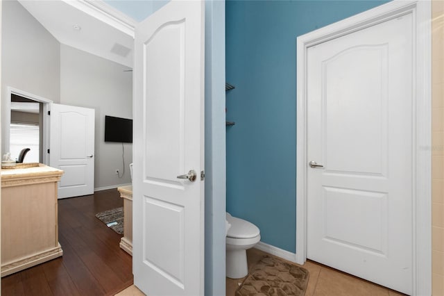 bathroom featuring visible vents, baseboards, toilet, and wood finished floors