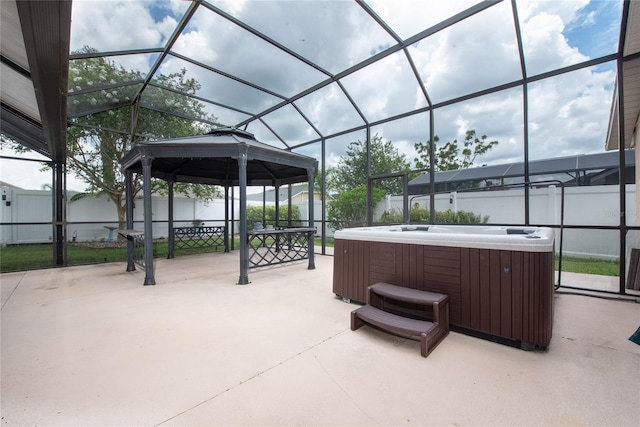 view of patio / terrace with a gazebo, glass enclosure, a hot tub, and a fenced backyard