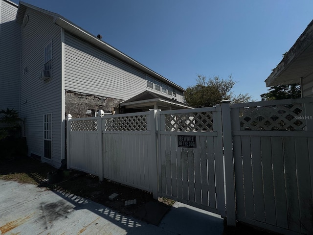 view of gate with cooling unit and fence