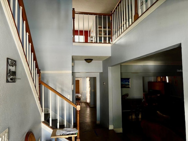 stairway with baseboards and a towering ceiling