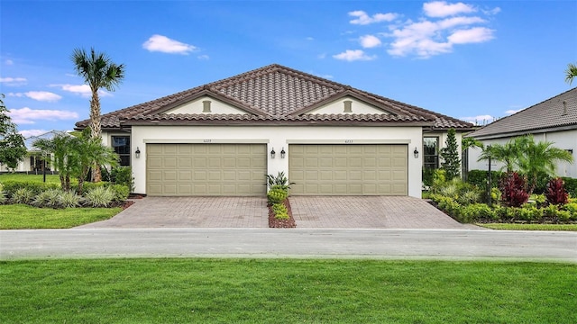 view of front of property featuring stucco siding, an attached garage, a tile roof, and driveway