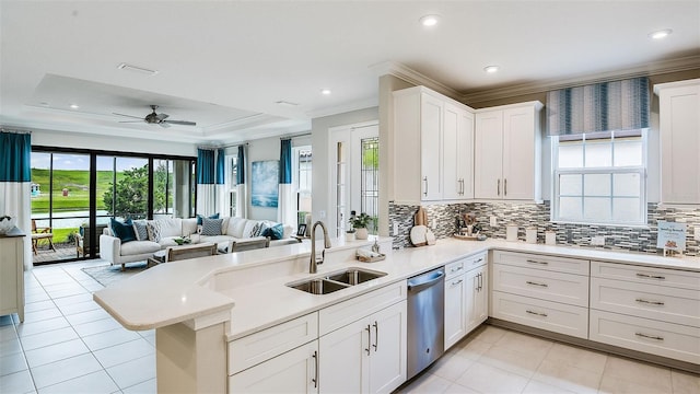 kitchen with ornamental molding, dishwasher, a peninsula, and a sink