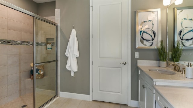 bathroom featuring vanity, a shower stall, baseboards, and tile patterned floors