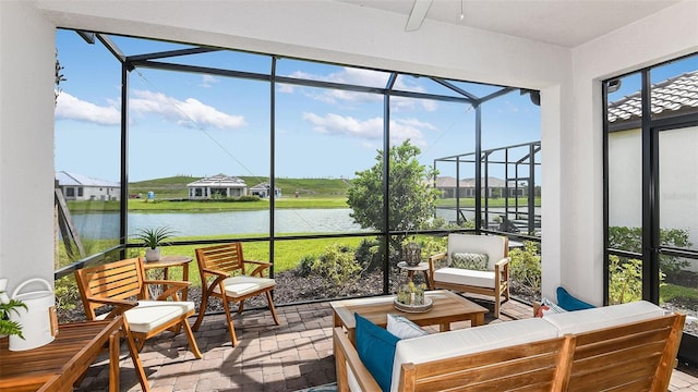 sunroom / solarium with ceiling fan and a water view