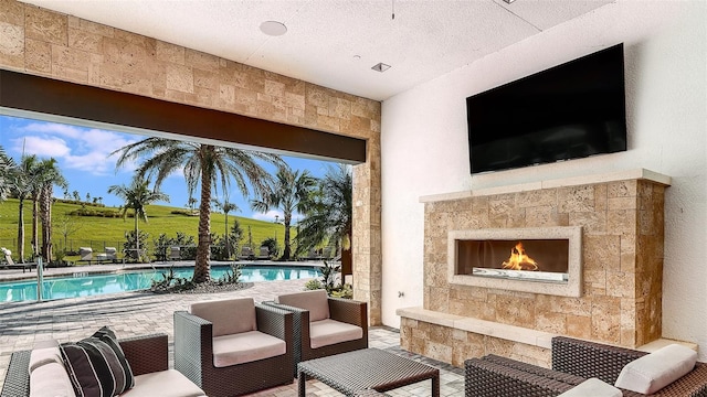 view of patio featuring a community pool and a lit fireplace