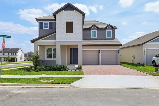 16354 Silver Grove Blvd, Winter Garden, FL 34787 - view of front of home featuring decorative driveway, covered porch, stucco siding, and an attached garage