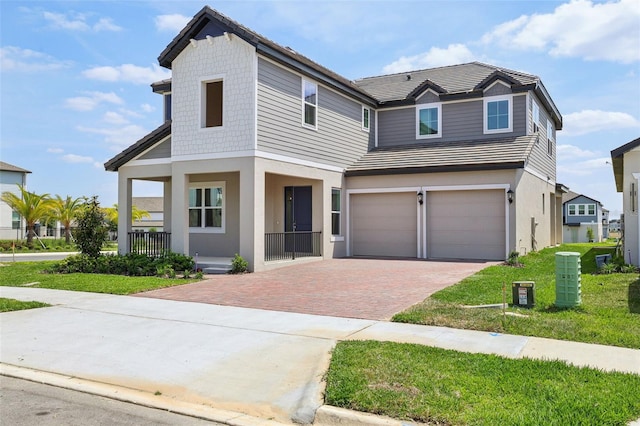 16354 Silver Grove Blvd, Winter Garden, FL 34787 - view of front of home featuring covered porch, decorative driveway, an attached garage, and stucco siding
