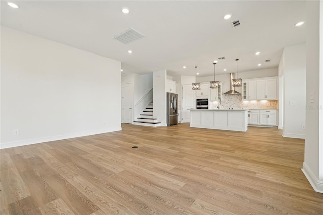 16354 Silver Grove Blvd, Winter Garden, FL 34787 - unfurnished living room with light wood-style floors, stairs, baseboards, recessed lighting, and a sink