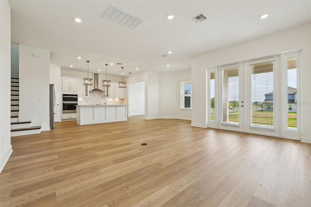 16354 Silver Grove Blvd, Winter Garden, FL 34787 - unfurnished living room with healthy amount of natural light, light wood-style flooring, stairway, and recessed lighting