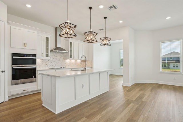 16354 Silver Grove Blvd, Winter Garden, FL 34787 - kitchen with a sink, wall chimney exhaust hood, double oven, tasteful backsplash, and light countertops