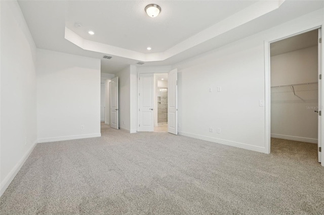 16354 Silver Grove Blvd, Winter Garden, FL 34787 - unfurnished bedroom with light colored carpet, baseboards, a raised ceiling, recessed lighting, and a walk in closet